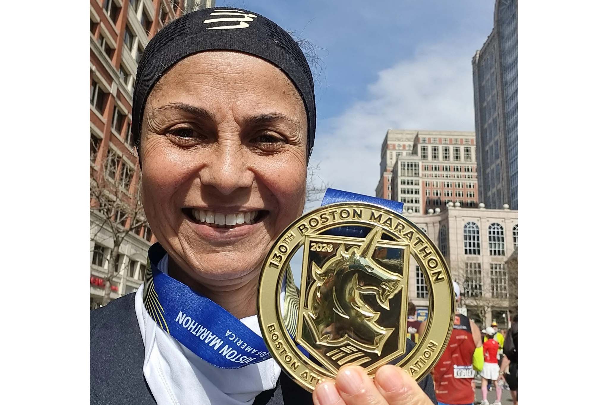 Marcia Simoni, servidora da SEES, com a medalha da Maratona de Boston
