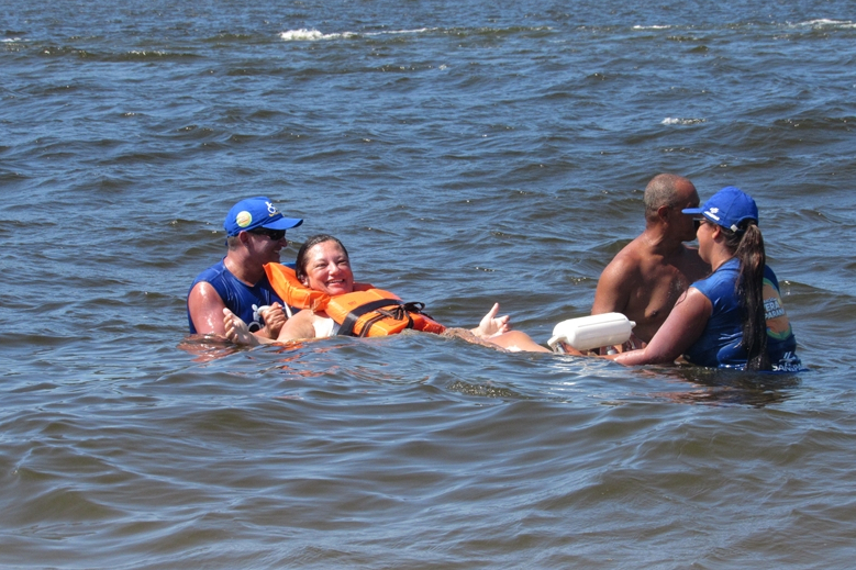 Com dificuldades extremas de caminhar, Débora Leia dos Santos tem tomado pelo menos dois banhos de mar por dia graças às cadeiras anfíbias disponibilizadas no Balneário Caieiras, no município de Guaratuba. Foto: Sanepar
