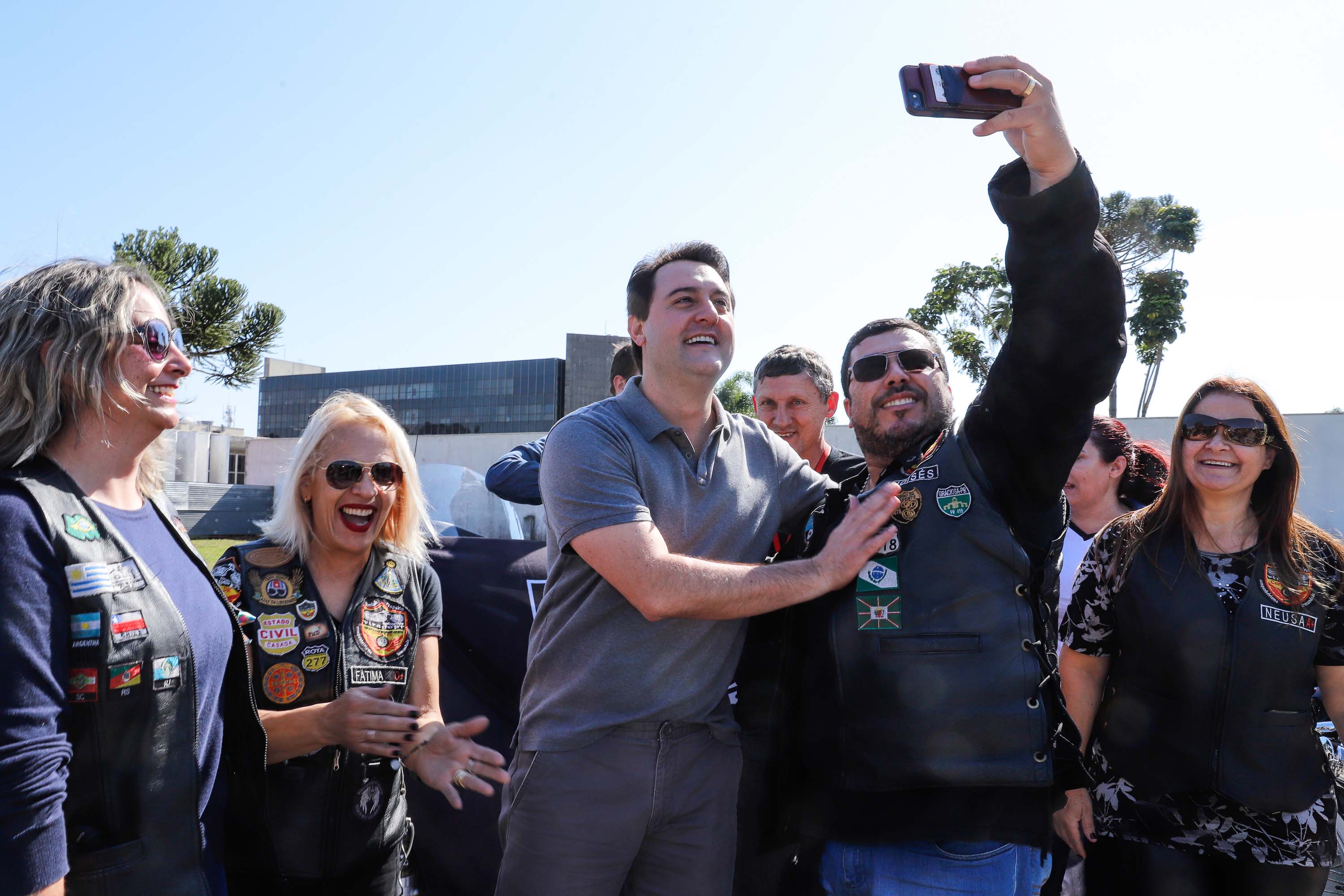 O governador Carlos Massa Ratinho Junior disse neste sábado (27) que o Governo do Paraná prepara, em parceria com motociclistas, uma agenda turística robusta para integrar ainda mais os clubes e potencializar as viagens ao encontro das belezas naturais do Estado. Ele participou das comemorações da 1ª Moto União, no Palácio Iguaçu, evento idealizado pelo Departamento de Trânsito do Paraná (Detran-PR) que passa a fazer parte do calendário estadual em razão do Dia do Motociclista.