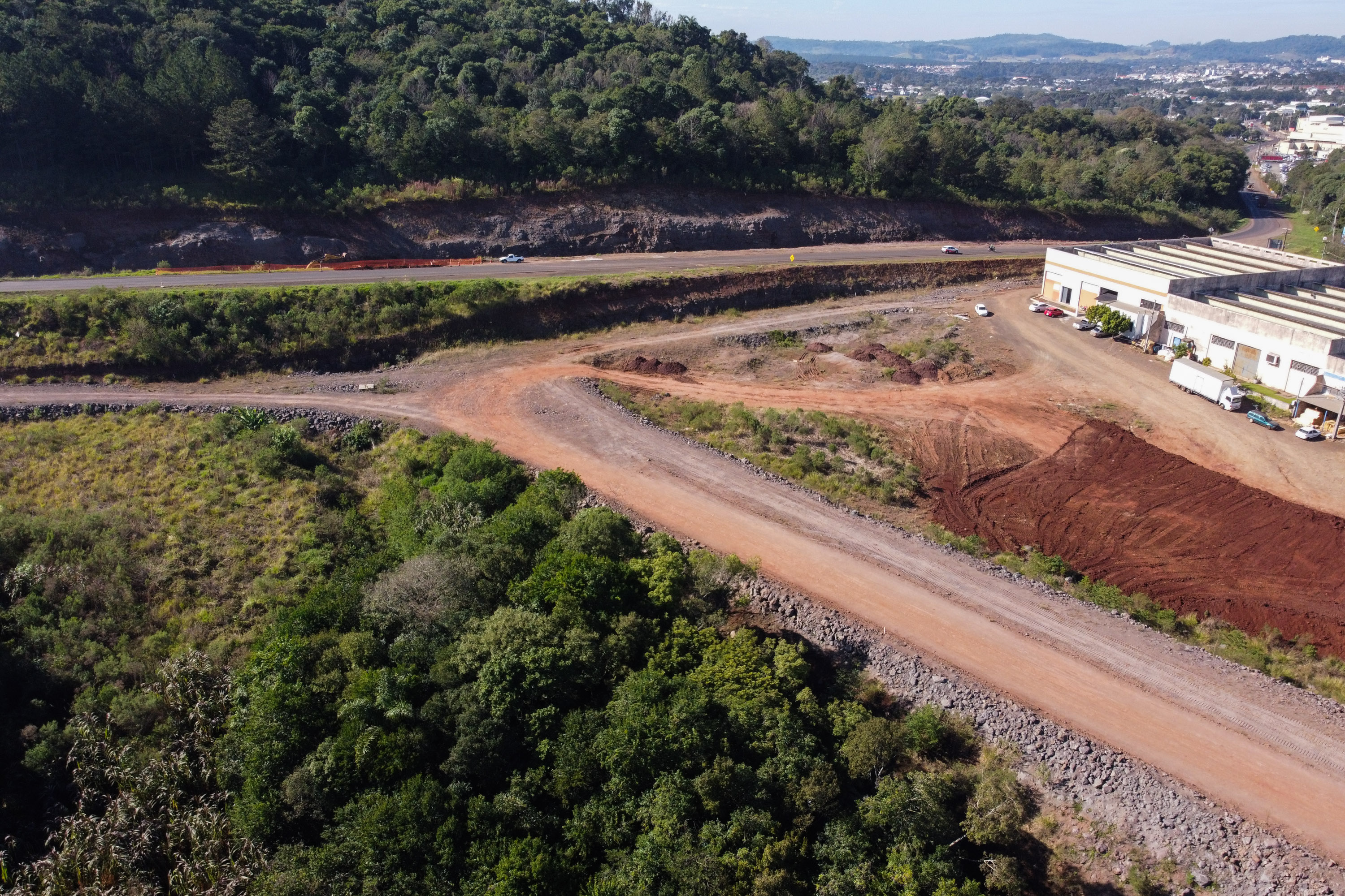 Serviços de terraplanagem, pavimentação e drenagem do Contorno Noroeste em Francisco Beltrao, que irá tirar o tráfego pesado de caminhões de dentro da cidade. O acesso rodoviário terá 5,2 quilômetros de extensão, ligando a PR-180 com a PR-483, e contará com cinco trincheiras e viadutos, duas faixas, além de acostamentos com 2,5 metros de largura e mais de dois quilômetros de terceiras faixas.Foto: Geraldo Bubniak/AEN