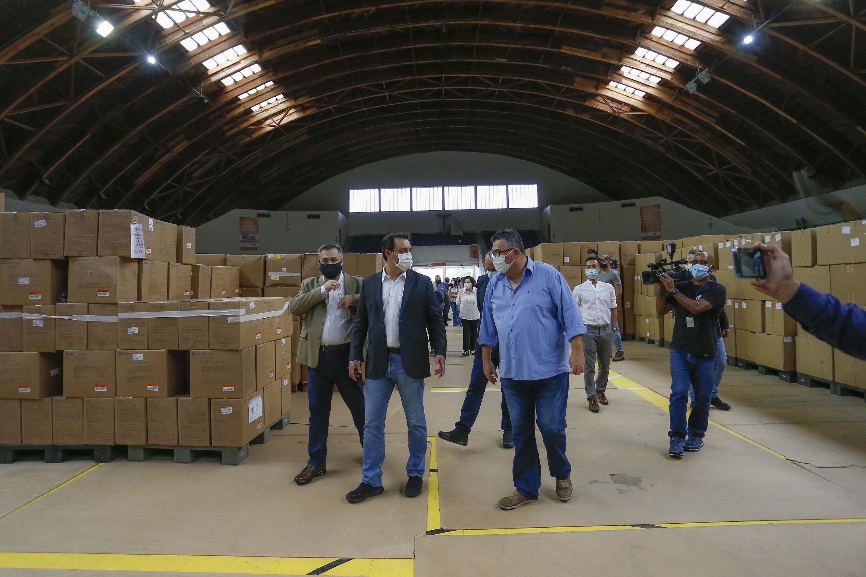O governador Carlos Massa Ratinho Junior vistoriou nesta quarta-feira (12) o estoque dos chamados “insumos secos” que o Paraná já tem disponível para iniciar o processo de vacinação contra a Covid-19. São agulhas, seringas, máscaras, luvas, aventais e algodão, entre outros itens, que estão centralizados em dois pontos principais em Curitiba: o Centro de Medicamentos do Paraná (Cemepar) e o Ginásio de Esportes do Tarumã.
Foto: Jonathan Campos/AEN