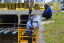 Empregados da Sanepar instalam ecobarreira em canal de Matinhos para conter lixo que iria ao mar 