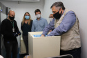 O  Secretário de Estado da Saúde, Beto Preto e o vice-prefeito Eduardo Pimentel recebem o primeiro lote de  32.760 doses de vacinas contra a Covid-19 da  Pfizer   no Centro de Medicamentos do Paraná (Cemepar), em Curitiba, na noite desta segunda-feira (3).  Foto: Geraldo Bubniak/AEN