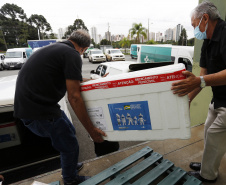 Funcionários do Cemepar carregando vacinas contra a Covid 19, para as 22 regionais de saúide do Paraná 