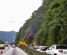 Morretes, 10 de fevereiro de 2023 - Guindastes realizam a recuperação do morro na BR 277, sentindo litoral paranaense, nas proximidades do viaduto do padre.