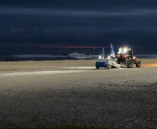 Máquina saneadora inicia limpeza da areia da praia