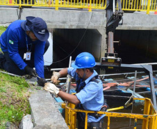 Empregados da Sanepar instalam ecobarreira em canal de Matinhos para conter lixo que iria ao mar 