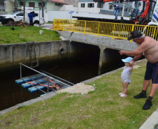 Empregados da Sanepar instalam ecobarreira em canal de Matinhos para conter lixo que iria ao mar 