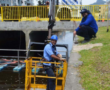 Empregados da Sanepar instalam ecobarreira em canal de Matinhos para conter lixo que iria ao mar 