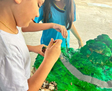 Alunos de escola municipal fazendo trabalho escolar sobre a Ponte de Guaratuba