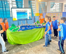 Alunos de escola municipal fazendo trabalho escolar sobre a Ponte de Guaratuba