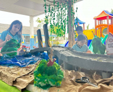 Alunos de escola municipal fazendo trabalho escolar sobre a Ponte de Guaratuba
