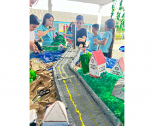 Alunos de escola municipal fazendo trabalho escolar sobre a Ponte de Guaratuba