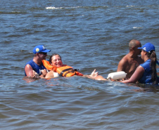Com dificuldades extremas de caminhar, Débora Leia dos Santos tem tomado pelo menos dois banhos de mar por dia graças às cadeiras anfíbias disponibilizadas no Balneário Caieiras, no município de Guaratuba. Foto: Sanepar