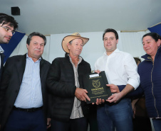 Cinquenta e seis famílias de produtores rurais ocupantes de terras pertencentes ao Estado (devolutas) em Pitanga e Boa Ventura do São Roque, no Centro do Paraná, receberam nesta sexta-feira (7) os títulos de propriedade de seus imóveis. Aguardado há anos pelas famílias, o documento de regularização das terras foi entregue em encontro com o governador Carlos Massa Ratinho Junior, realizado em Pitanga. Foto: Rodrigo Felix Leal/ANPr