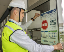 A partir desta semana, os trabalhadores que entram no cais público do Porto de Paranaguá recebem informações claras sobre as regras gerais de segurança e o regulamento da rota de tráfego de veículos e pedestres. Além de banners e cartazes, são entregues cartilhas com orientações de velocidade, equipamentos e práticas para tornar o ambiente portuário mais seguro. O conteúdo também está disponível no site da Portos do Paraná (www.portosdoparana.pr.gov.br).