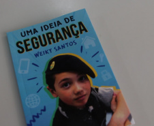 Aos 14 anos, Weiky Santos, filho do soldado Wanderley Rodrigues dos Santos, já é Youtuber e autor de um livro para crianças. “Uma ideia de segurança” trata de assuntos variados, mas, dentre as 120 páginas, divididas em 10 capítulos, a família ganha destaque. Na obra, o adolescente orienta os mais novos sobre abuso sexual, perigos na internet, bullying, drogas e o que fazer se der vontade de fugir de casa. 
Foto:SESP
