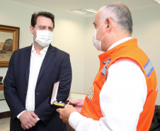 O governador Carlos Massa Ratinho Junior afirmou nesta quarta-feira (21) que a Casa Militar e a Defesa Civil do Estado desempenham papel fundamental de apoio à população no enfrentamento da pandemia do novo coronavírus no Paraná, a primeira com a logística do transporte aéreo dos testes e a segunda com a capacidade de organização e distribuição de insumos e Equipamentos de Proteção Individual (EPIs), além da participação efetiva em ações solidárias e de ajuda humanitária