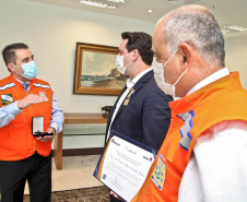O governador Carlos Massa Ratinho Junior afirmou nesta quarta-feira (21) que a Casa Militar e a Defesa Civil do Estado desempenham papel fundamental de apoio à população no enfrentamento da pandemia do novo coronavírus no Paraná, a primeira com a logística do transporte aéreo dos testes e a segunda com a capacidade de organização e distribuição de insumos e Equipamentos de Proteção Individual (EPIs), além da participação efetiva em ações solidárias e de ajuda humanitária