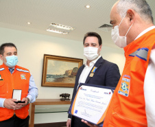 O governador Carlos Massa Ratinho Junior afirmou nesta quarta-feira (21) que a Casa Militar e a Defesa Civil do Estado desempenham papel fundamental de apoio à população no enfrentamento da pandemia do novo coronavírus no Paraná, a primeira com a logística do transporte aéreo dos testes e a segunda com a capacidade de organização e distribuição de insumos e Equipamentos de Proteção Individual (EPIs), além da participação efetiva em ações solidárias e de ajuda humanitária