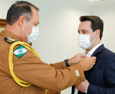 Ratinho Junior fez reconhecimento ao trabalho dos profissionais durante cerimônia reservada. O governador Ratinho Junior foi agraciado com a Medalha de Mérito da Casa Militar e a Medalha de Mérito da Defesa Civil.