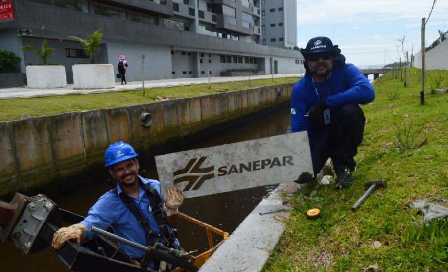 Empregados da Sanepar instalam ecobarreira em canal de Matinhos para conter lixo que iria ao mar