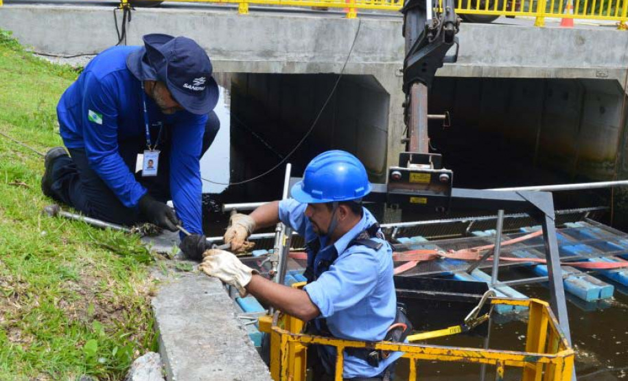 Empregados da Sanepar instalam ecobarreira em canal de Matinhos para conter lixo que iria ao mar
