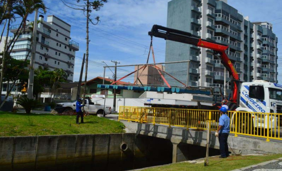 Empregados da Sanepar instalam ecobarreira em canal de Matinhos para conter lixo que iria ao mar