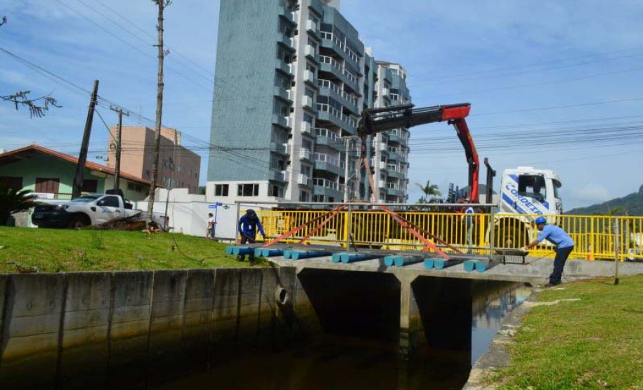 Empregados da Sanepar instalam ecobarreira em canal de Matinhos para conter lixo que iria ao mar
