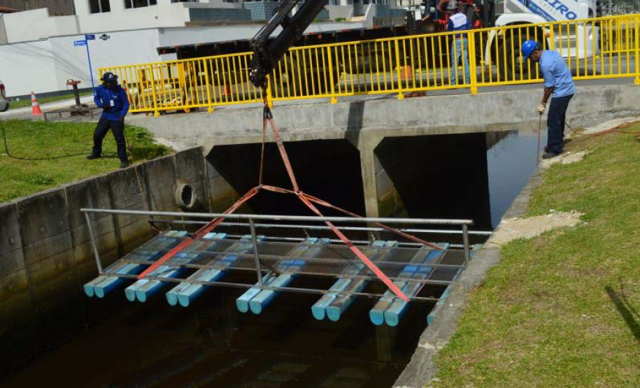Empregados da Sanepar instalam ecobarreira em canal de Matinhos para conter lixo que iria ao mar