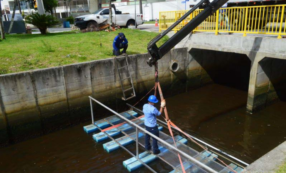 Empregados da Sanepar instalam ecobarreira em canal de Matinhos para conter lixo que iria ao mar