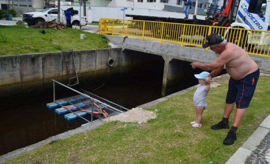 Empregados da Sanepar instalam ecobarreira em canal de Matinhos para conter lixo que iria ao mar