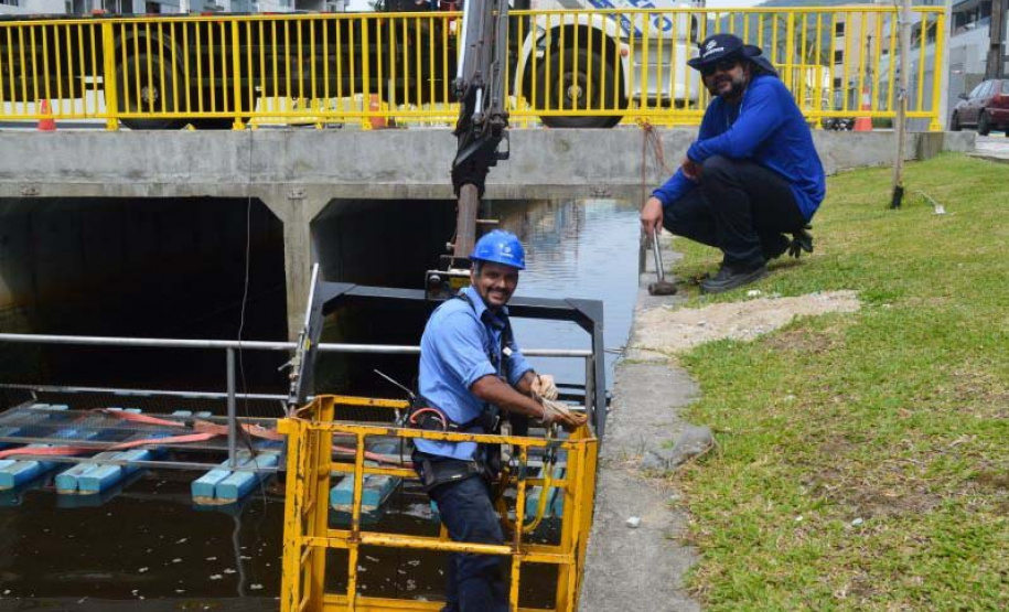 Empregados da Sanepar instalam ecobarreira em canal de Matinhos para conter lixo que iria ao mar