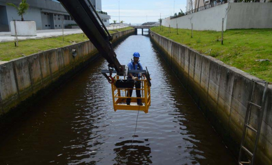 Empregados da Sanepar instalam ecobarreira em canal de Matinhos para conter lixo que iria ao mar