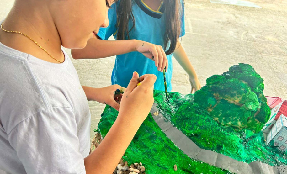 Alunos de escola municipal fazendo trabalho escolar sobre a Ponte de Guaratuba