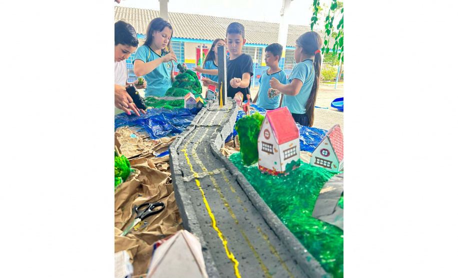 Alunos de escola municipal fazendo trabalho escolar sobre a Ponte de Guaratuba