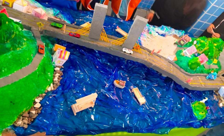 Alunos de escola municipal fazendo trabalho escolar sobre a Ponte de Guaratuba