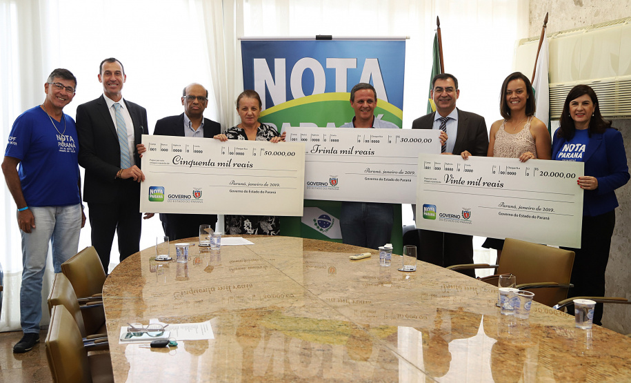 O secretário da Fazenda, Renê Garcia Júnior, entregou nesta segunda-feira (21) os três principais prêmios do 38º sorteio do Nota Paraná, que aconteceu no último dia 10 de janeiro. Uma moradora de Londrina, uma instituição, também de Londrina, e uma moradora de Colombo, na Região Metropolitana de Curitiba, foram os ganhadores dos prêmios de R$ 50 mil, R$ 30 mil e R$ 20 mil, respectivamente. - Curitiba, 21/01/2018 - Foto: José Fernando Ogura/ANPr