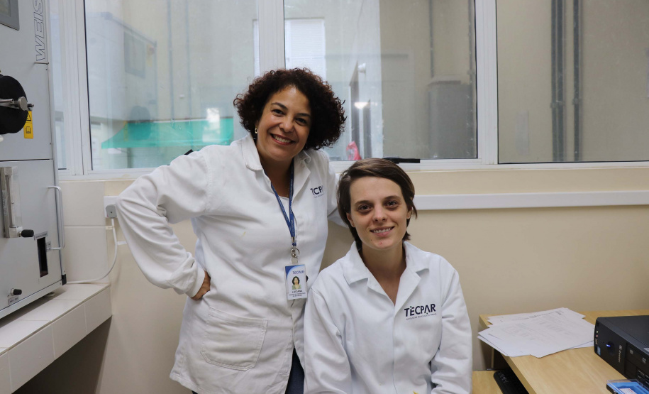 Estudantes paranaenses de graduação e pós-graduação contam com o apoio do Instituto de Tecnologia do Paraná (Tecpar) para o desenvolvimento de pesquisas acadêmicas que necessitam de equipamentos e laboratórios especializados. Na foto,  aluna de doutorado em Física da Universidade Federal do Paraná (UFPR), Deize Grodniski (sentada) e a colaboradora do Tecpar Luciana Barreto Adad, mestre em Engenharia e Ciência dos Materiais (em pé).  Foto: Divulgação/Tecpar