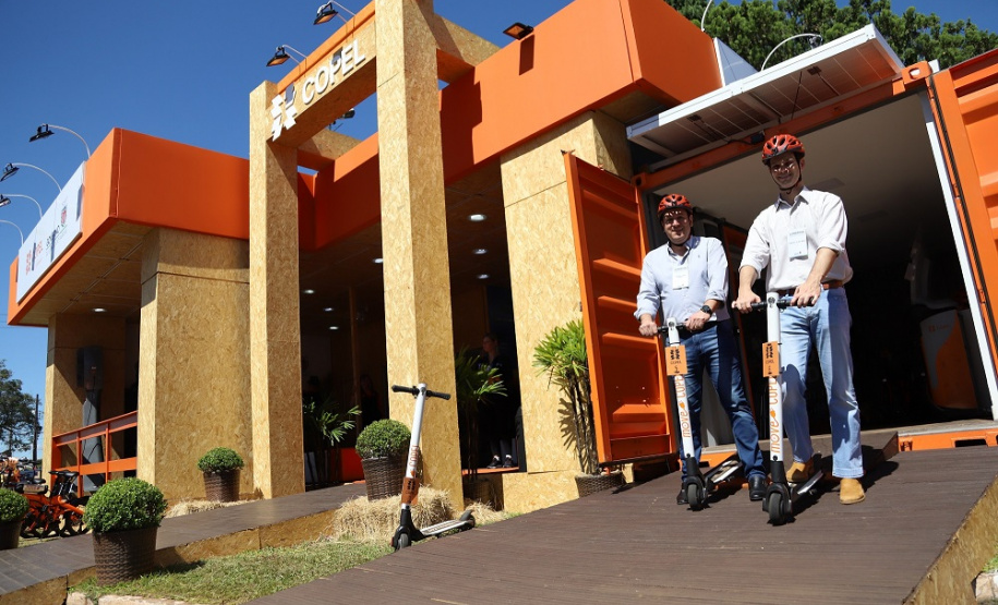 A partir desta quinta-feira (09), os visitantes da Expoingá poderão conhecer mais sobre geração distribuída, mobilidade elétrica e sobre o uso seguro e eficiente da energia, na Estação Copel montada na feira.
A principal novidade do estande próximo à entrada principal do Parque Internacional Francisco Feio Ribeiro fica por conta do empréstimo de bicicletas e patinetes elétricos. Foto: Divulgação/Copel
