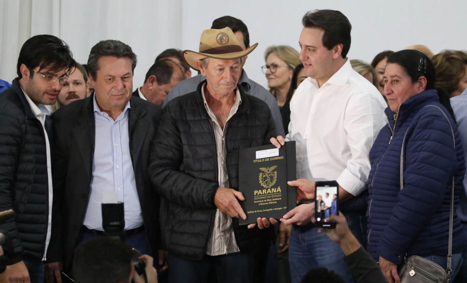 Cinquenta e seis famílias de produtores rurais ocupantes de terras pertencentes ao Estado (devolutas) em Pitanga e Boa Ventura do São Roque, no Centro do Paraná, receberam nesta sexta-feira (7) os títulos de propriedade de seus imóveis. Aguardado há anos pelas famílias, o documento de regularização das terras foi entregue em encontro com o governador Carlos Massa Ratinho Junior, realizado em Pitanga.   Foto: José Fernando Ogura/ANPr