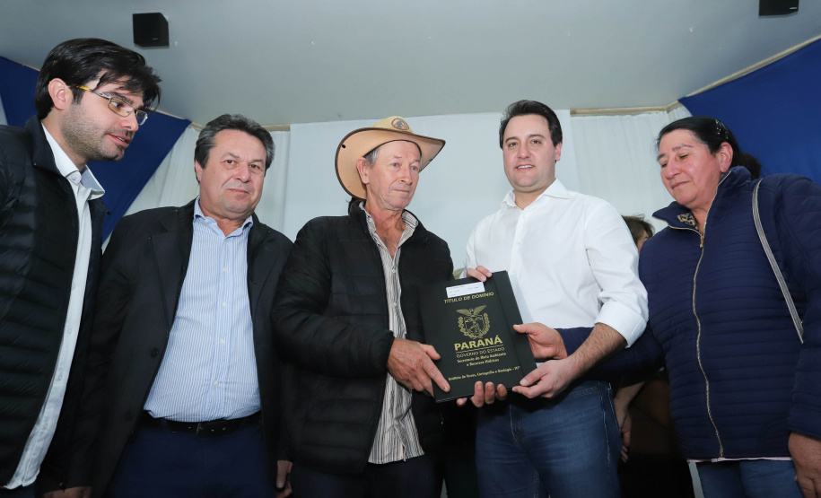 Cinquenta e seis famílias de produtores rurais ocupantes de terras pertencentes ao Estado (devolutas) em Pitanga e Boa Ventura do São Roque, no Centro do Paraná, receberam nesta sexta-feira (7) os títulos de propriedade de seus imóveis. Aguardado há anos pelas famílias, o documento de regularização das terras foi entregue em encontro com o governador Carlos Massa Ratinho Junior, realizado em Pitanga. Foto: Rodrigo Felix Leal/ANPr