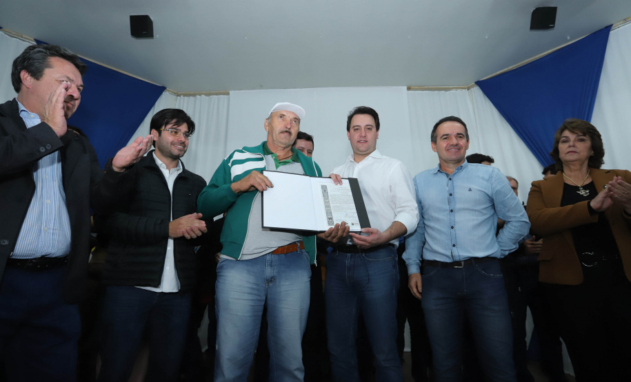 Cinquenta e seis famílias de produtores rurais ocupantes de terras pertencentes ao Estado (devolutas) em Pitanga e Boa Ventura do São Roque, no Centro do Paraná, receberam nesta sexta-feira (7) os títulos de propriedade de seus imóveis. Aguardado há anos pelas famílias, o documento de regularização das terras foi entregue em encontro com o governador Carlos Massa Ratinho Junior, realizado em Pitanga. Foto: Rodrigo Felix Leal/ANPr