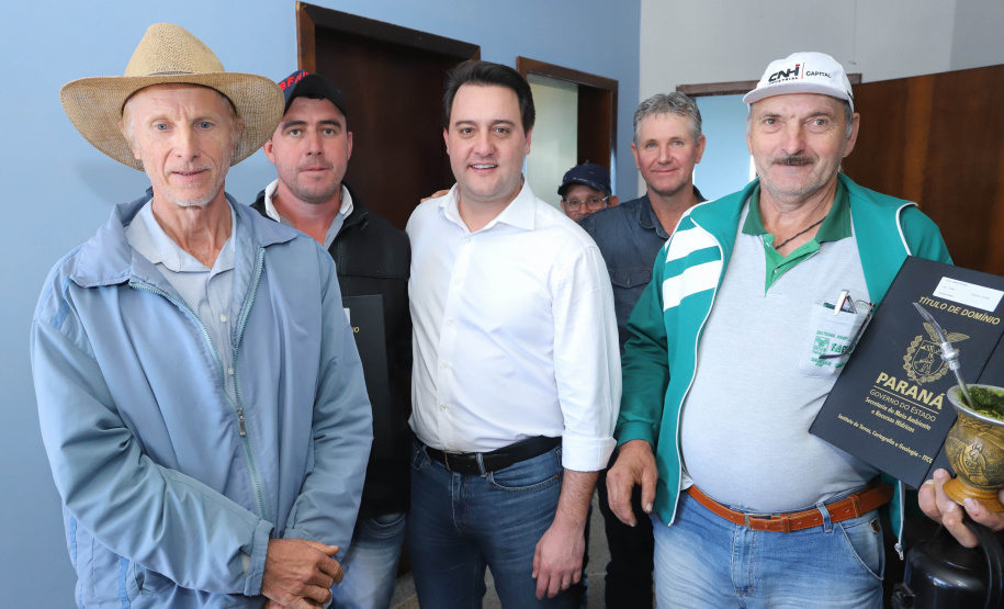 Cinquenta e seis famílias de produtores rurais ocupantes de terras pertencentes ao Estado (devolutas) em Pitanga e Boa Ventura do São Roque, no Centro do Paraná, receberam nesta sexta-feira (7) os títulos de propriedade de seus imóveis. Aguardado há anos pelas famílias, o documento de regularização das terras foi entregue em encontro com o governador Carlos Massa Ratinho Junior, realizado em Pitanga. Foto: Rodrigo Felix Leal/ANPr