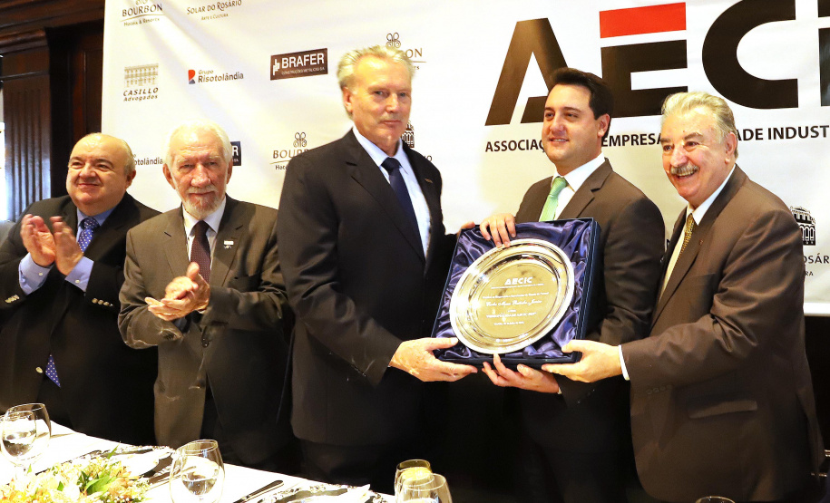 O governador Carlos Massa Ratinho Junior recebe de Nelson Hubner, presidente da AECIC, o título de Personalidade AECIC 2019.N/F: Nelson Hubner, presidente AECIC \; governador Ratinho Junior e  João Casilo, vice-presidente da AECIC.Curitiba, 01-07-19.Foto: Arnaldo Alves / ANPr.