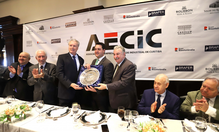 O governador Carlos Massa Ratinho Junior recebe de Nelson Hubner, presidente da AECIC, o título de Personalidade AECIC 2019.N/F: Nelson Hubner, presidente AECIC \; governador Ratinho Junior e  João Casilo, vice-presidente da AECIC.Curitiba, 01-07-19.Foto: Arnaldo Alves / ANPr.