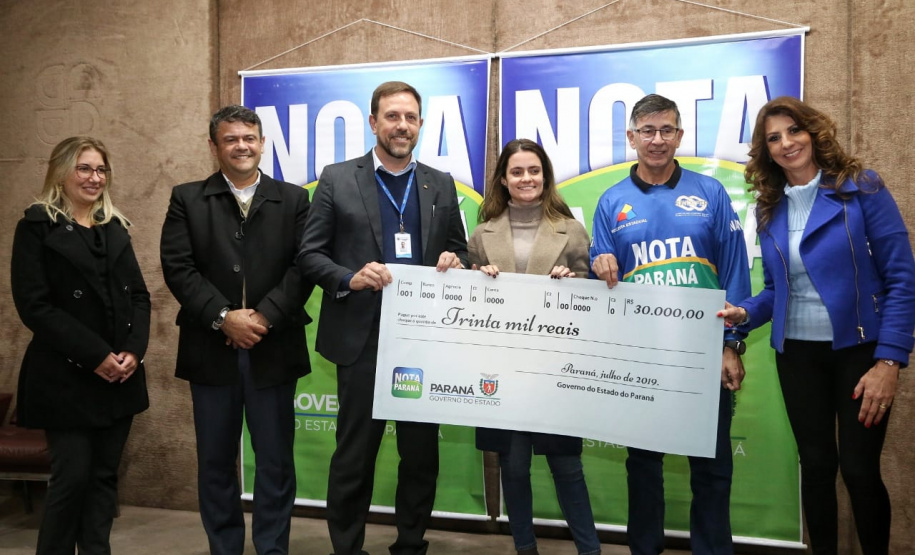 Todas de Curitiba e todas mulheres. São da Capital as três felizes ganhadoras dos prêmios do Nota Paraná deste mês de julho. Os cheques, de R$ 50 mil, R$ 30 mil e R$ 20 mil, foram entregues nesta quinta-feira (18) às três moradoras de Curitiba dos bairros Mossunguê, Hugo Lange e Campo Comprido. Foto: Gilson Abreu/ANPr