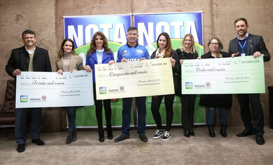 Todas de Curitiba e todas mulheres. São da Capital as três felizes ganhadoras dos prêmios do Nota Paraná deste mês de julho. Os cheques, de R$ 50 mil, R$ 30 mil e R$ 20 mil, foram entregues nesta quinta-feira (18) às três moradoras de Curitiba dos bairros Mossunguê, Hugo Lange e Campo Comprido. Foto: Gilson Abreu/ANPr