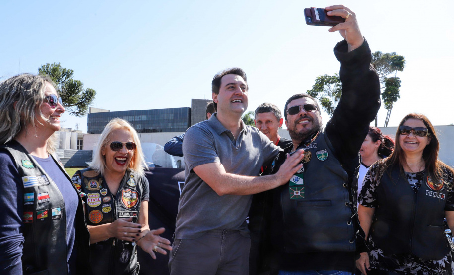 O governador Carlos Massa Ratinho Junior disse neste sábado (27) que o Governo do Paraná prepara, em parceria com motociclistas, uma agenda turística robusta para integrar ainda mais os clubes e potencializar as viagens ao encontro das belezas naturais do Estado. Ele participou das comemorações da 1ª Moto União, no Palácio Iguaçu, evento idealizado pelo Departamento de Trânsito do Paraná (Detran-PR) que passa a fazer parte do calendário estadual em razão do Dia do Motociclista.