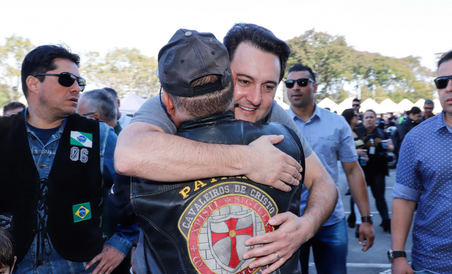 O governador Carlos Massa Ratinho Junior disse neste sábado (27) que o Governo do Paraná prepara, em parceria com motociclistas, uma agenda turística robusta para integrar ainda mais os clubes e potencializar as viagens ao encontro das belezas naturais do Estado. Ele participou das comemorações da 1ª Moto União, no Palácio Iguaçu, evento idealizado pelo Departamento de Trânsito do Paraná (Detran-PR) que passa a fazer parte do calendário estadual em razão do Dia do Motociclista.
